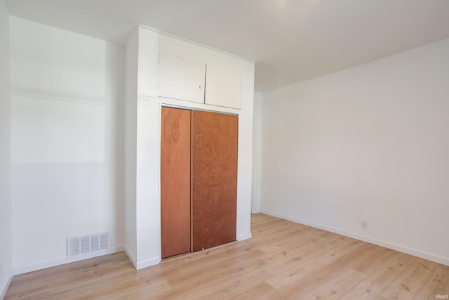 unfurnished bedroom with a closet and light hardwood / wood-style floors