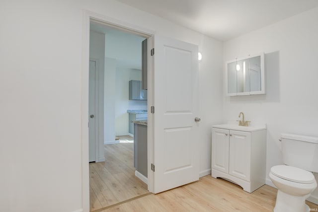 bathroom with hardwood / wood-style floors, vanity, and toilet