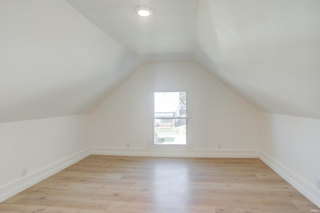 bonus room featuring light wood-type flooring and vaulted ceiling