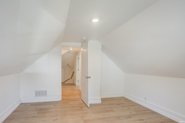 additional living space with vaulted ceiling and light wood-type flooring