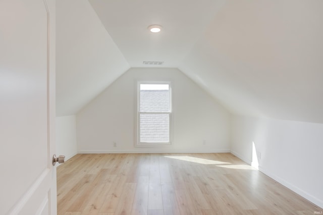 bonus room with lofted ceiling and light wood-type flooring