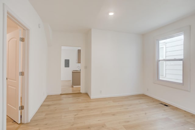 unfurnished room featuring light hardwood / wood-style floors and electric panel