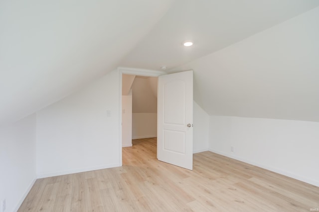 additional living space with light hardwood / wood-style floors and lofted ceiling