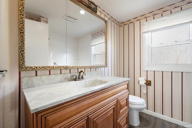 bathroom featuring vanity, toilet, hardwood / wood-style flooring, and plenty of natural light