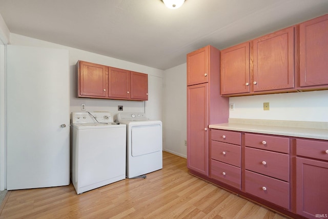 clothes washing area featuring independent washer and dryer, cabinets, and light hardwood / wood-style flooring