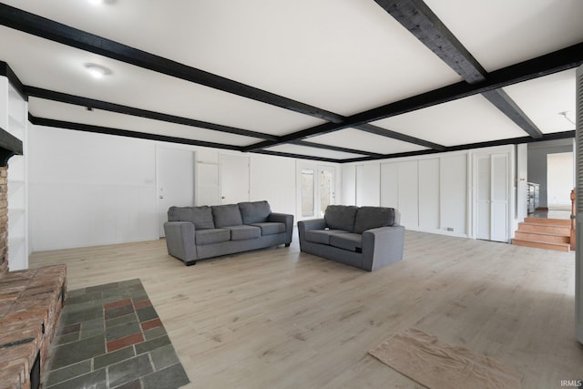 living room with beamed ceiling and light wood-type flooring