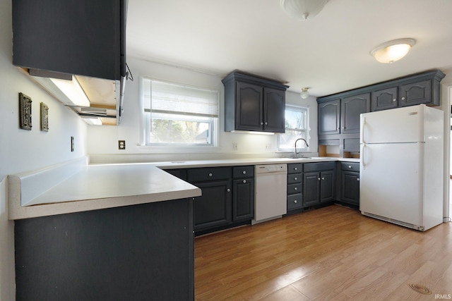 kitchen with sink, light hardwood / wood-style flooring, and white appliances