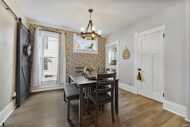 dining room with a chandelier, a barn door, crown molding, and dark hardwood / wood-style flooring