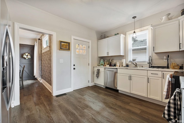 kitchen with pendant lighting, white cabinets, and stainless steel appliances