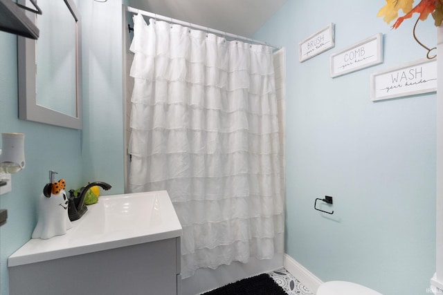 bathroom featuring vanity, toilet, and curtained shower