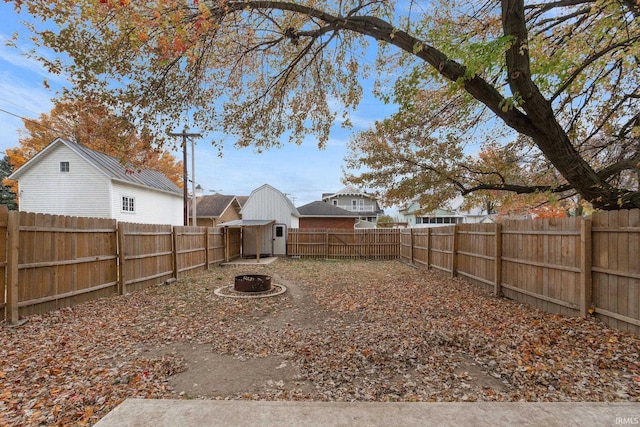 view of yard featuring an outdoor fire pit and a shed