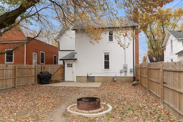 rear view of house with an outdoor fire pit and a patio