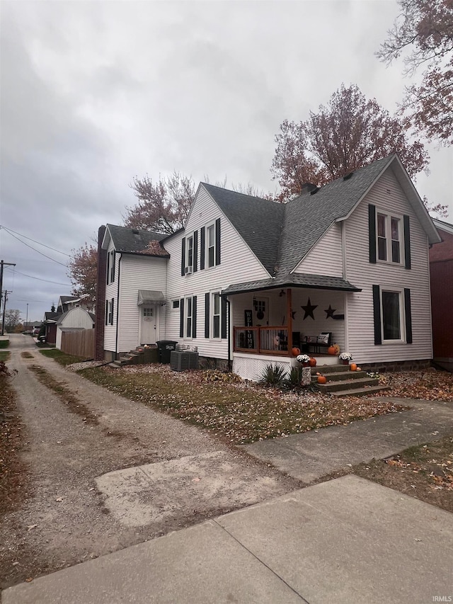 rear view of property featuring cooling unit and a porch