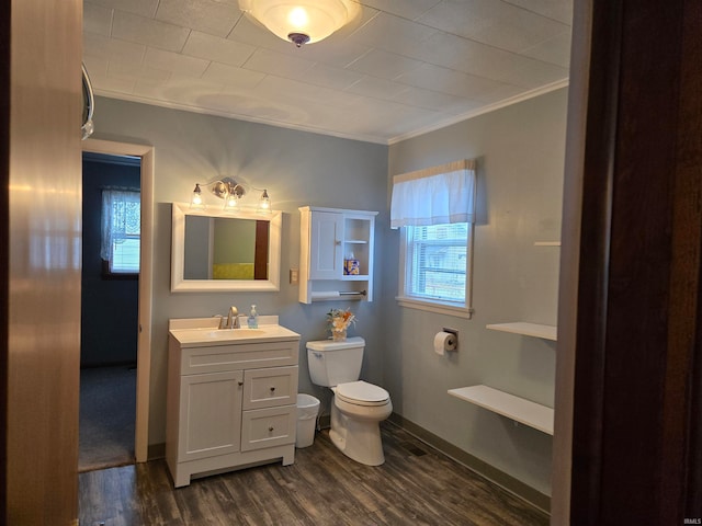 bathroom with crown molding, hardwood / wood-style floors, vanity, and toilet