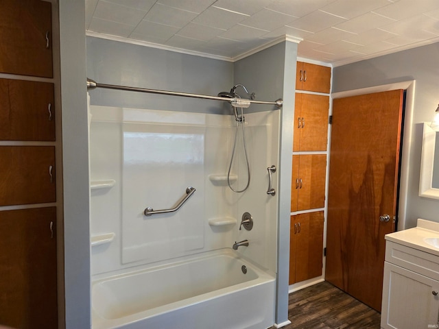 bathroom with hardwood / wood-style flooring, ornamental molding, vanity, and shower / bathing tub combination