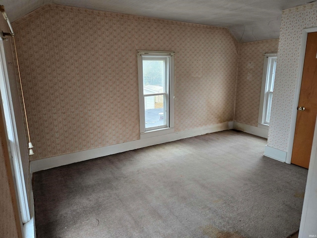 unfurnished room with vaulted ceiling and light colored carpet