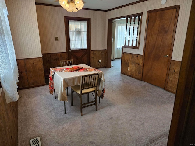 carpeted dining space with a chandelier