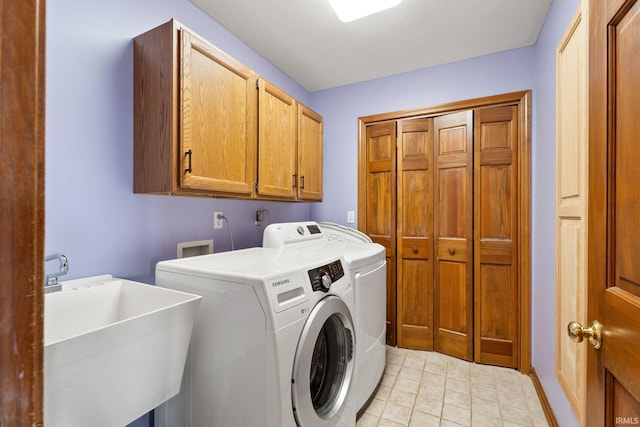 washroom featuring sink, cabinets, and washing machine and clothes dryer