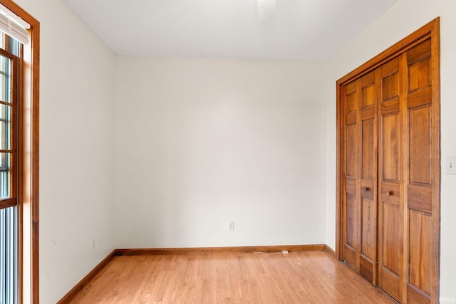 unfurnished bedroom with a closet, light hardwood / wood-style floors, and ceiling fan