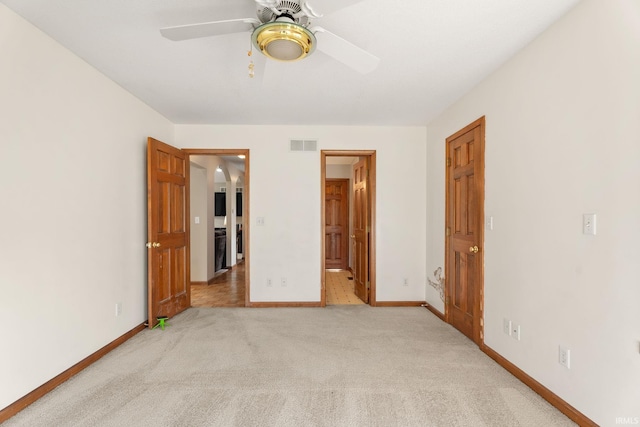 unfurnished bedroom with connected bathroom, light colored carpet, and ceiling fan