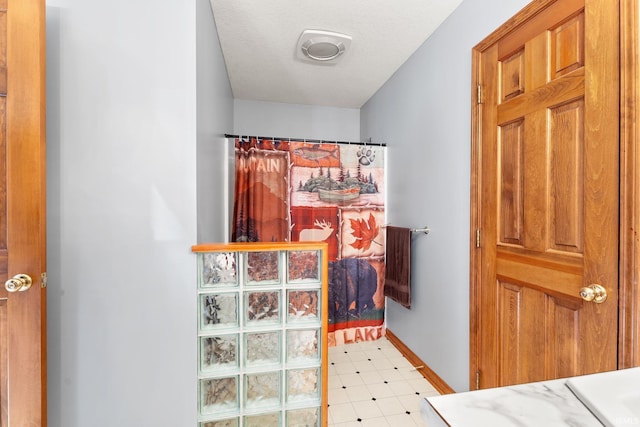 interior space featuring a textured ceiling and curtained shower