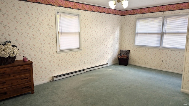 carpeted spare room featuring a healthy amount of sunlight, baseboard heating, and ceiling fan