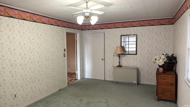 carpeted spare room with ornamental molding and ceiling fan