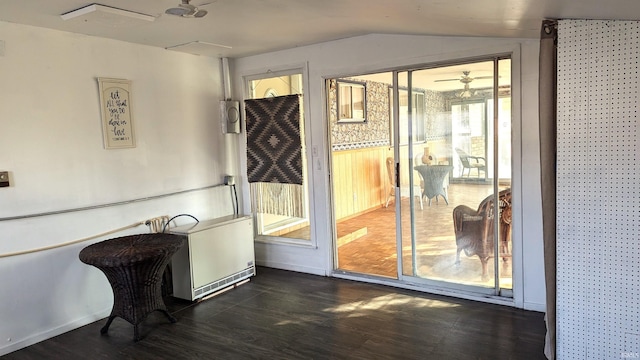 doorway to outside with dark hardwood / wood-style floors, ceiling fan, and vaulted ceiling