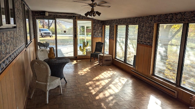 unfurnished sunroom featuring a wealth of natural light, vaulted ceiling, and ceiling fan