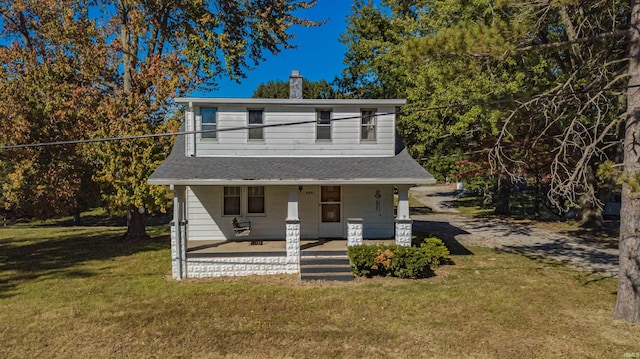 bungalow-style house featuring a chimney, a porch, and a front yard