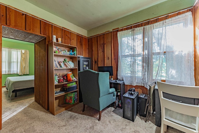 home office with light colored carpet and wood walls