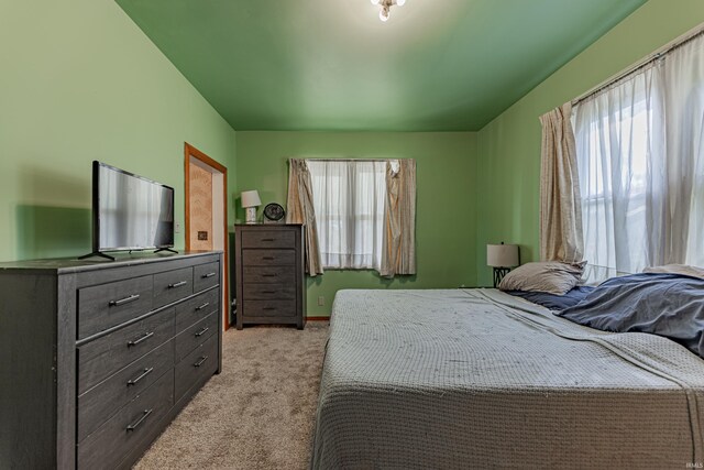 bedroom featuring light carpet and multiple windows