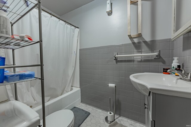 full bathroom with toilet, vanity, and tile walls