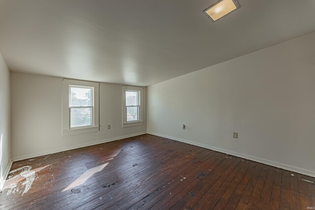 unfurnished room with dark wood-type flooring