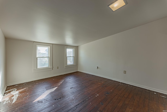 spare room with baseboards and hardwood / wood-style floors