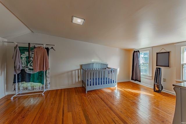 unfurnished bedroom featuring baseboards, hardwood / wood-style floors, and lofted ceiling