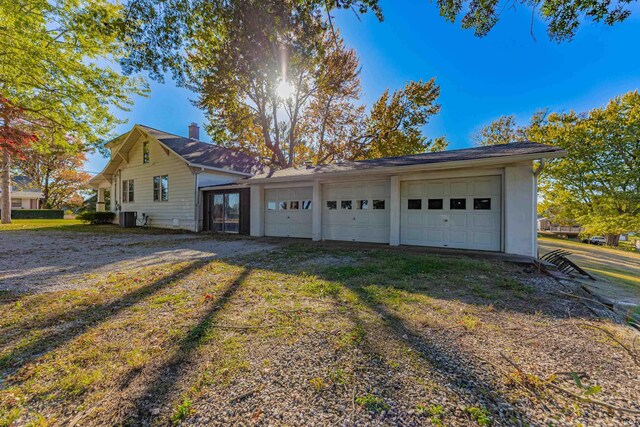 exterior space with central air condition unit and a garage