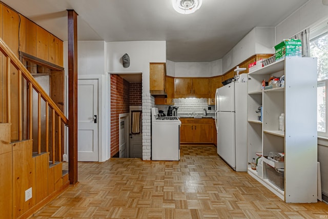 kitchen featuring open shelves, decorative backsplash, white appliances, brown cabinets, and a sink