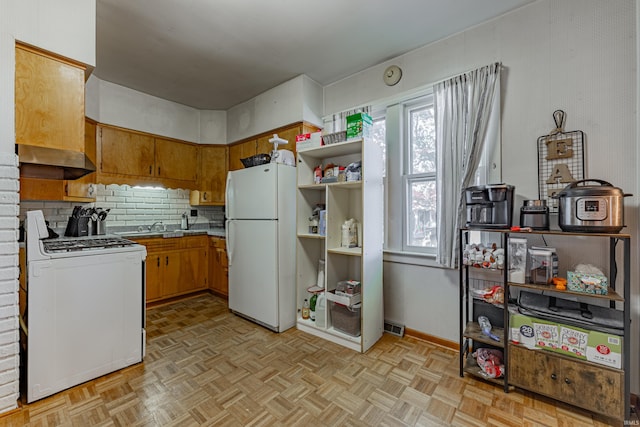 kitchen featuring range hood, light parquet flooring, decorative backsplash, and white appliances