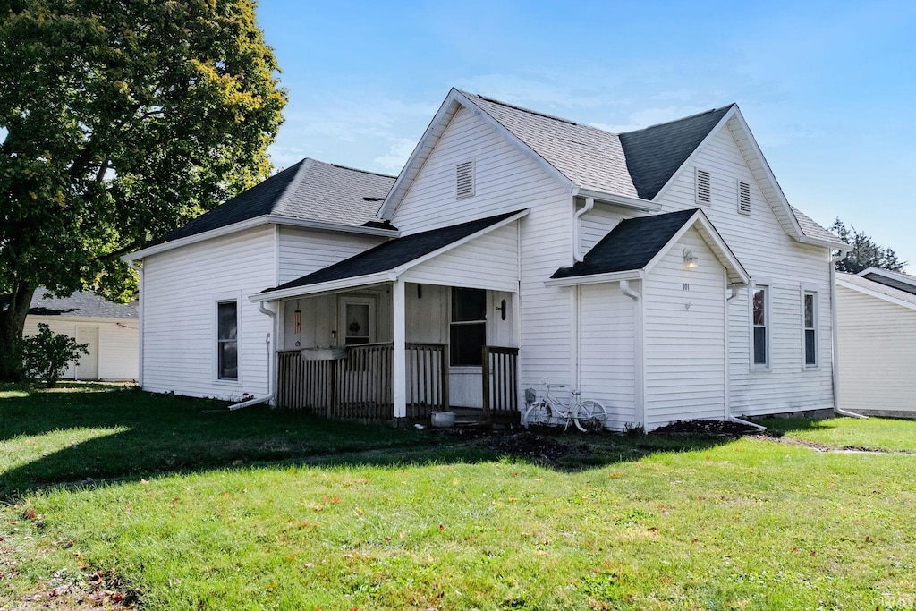 rear view of property with a lawn