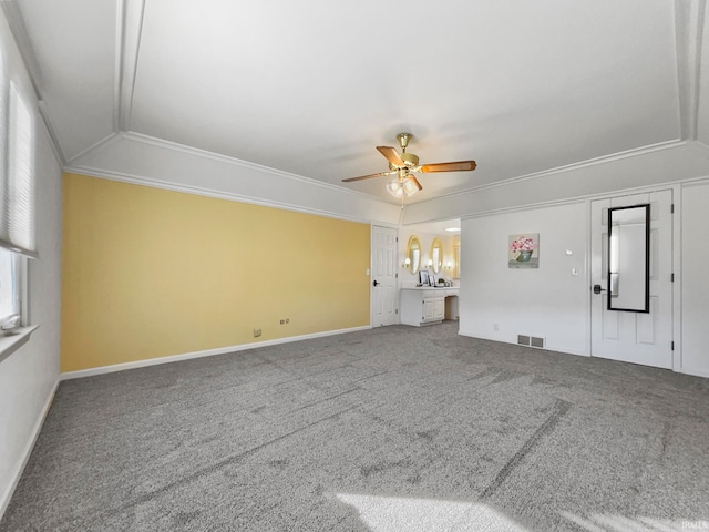 unfurnished living room with ceiling fan, ornamental molding, and carpet floors