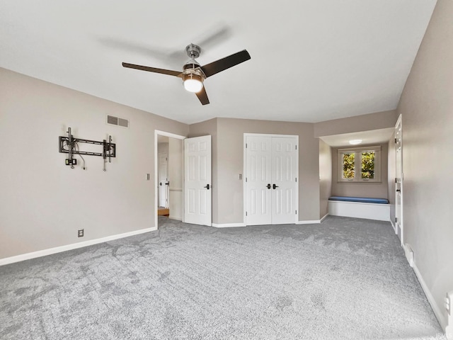 unfurnished bedroom with a closet, carpet flooring, and ceiling fan