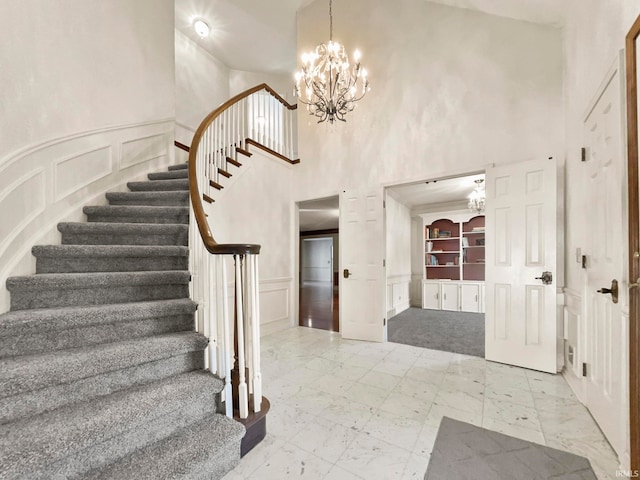 entryway featuring a towering ceiling and a chandelier