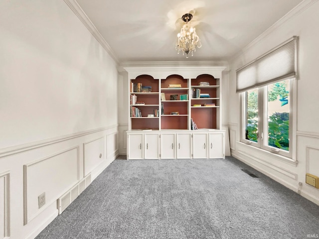 empty room featuring carpet, a notable chandelier, and crown molding