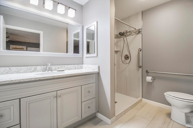 bathroom featuring vanity, a tile shower, and toilet