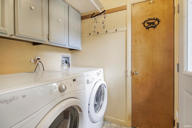 laundry area featuring washer and dryer and cabinets