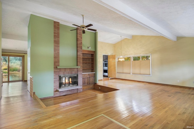 unfurnished living room featuring hardwood / wood-style floors, vaulted ceiling with beams, a textured ceiling, and a brick fireplace