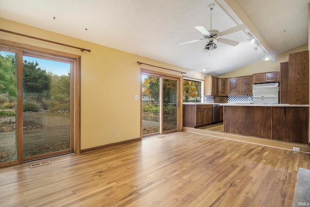 kitchen with lofted ceiling, appliances with stainless steel finishes, and a healthy amount of sunlight