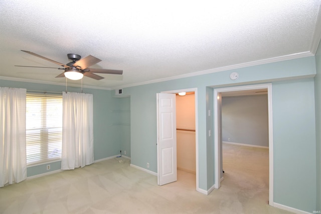 unfurnished bedroom with a closet, light carpet, ornamental molding, a textured ceiling, and ceiling fan