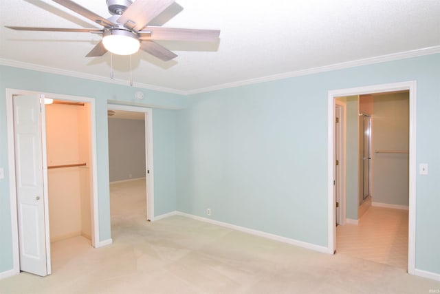 unfurnished bedroom with a closet, ornamental molding, light colored carpet, and ceiling fan